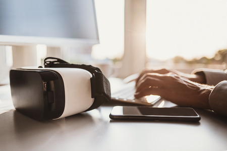 Business man using laptop computer with VR headset. Focus on virtual reality glassesの写真素材
