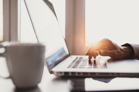 Men typing on computer keyboard. Businessman using laptop in the officeの写真素材