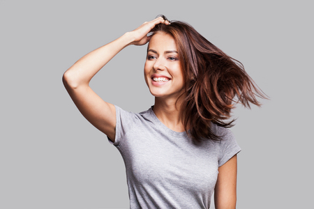 Attractive girl with long hair laughing, dancing and enjoying lifeの写真素材