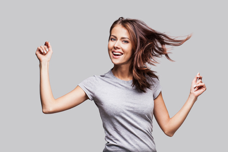 Pretty girl with long hair laughing, dancing and enjoying lifeの写真素材