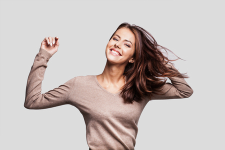 Happy girl with long hair laughing, dancing and enjoying lifeの写真素材