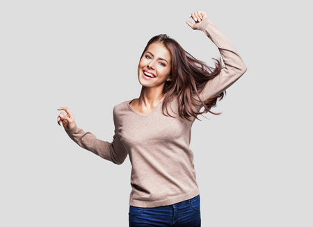 Pretty girl with long hair laughing, dancing and enjoying lifeの写真素材