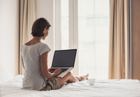 Young girl using laptop computer at homeの写真素材