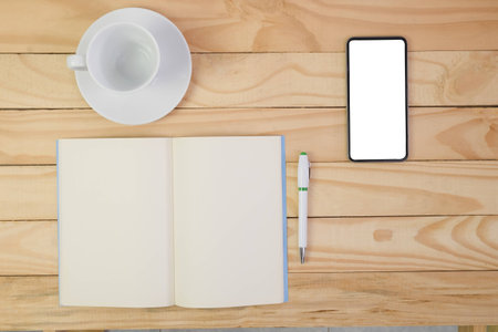 Blank note book, pen and cup of coffee on top wooden table.の写真素材
