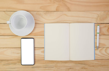 Blank note book, pen and cup of coffee on top wooden table.の写真素材