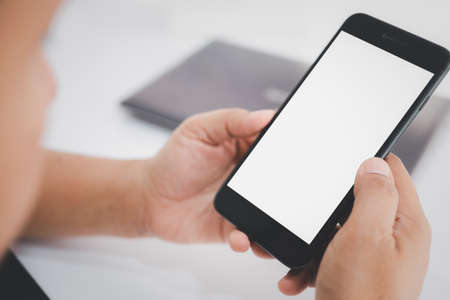 Hand holding smartphone with white screen.の写真素材