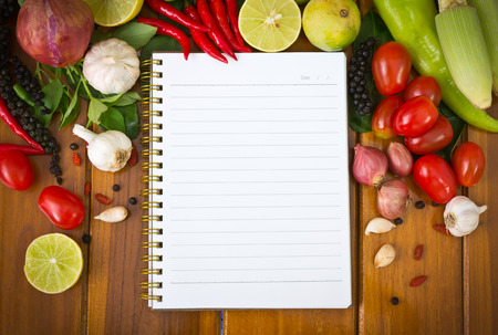 Fresh  vegetables and spices on a wooden background and paperの写真素材