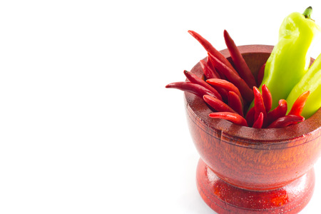 Sweet green chili and red hot chili in wooden mortarの写真素材