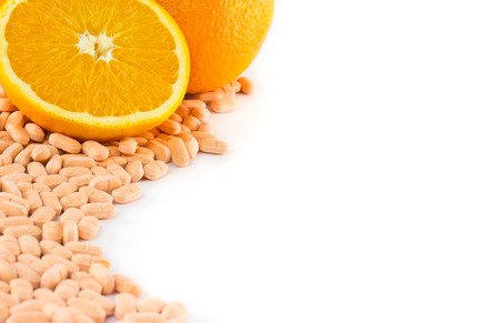 Orange fruit with vitamin c tablet on white backgroundの写真素材