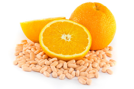 Orange fruit with vitamin c tablet on white backgroundの写真素材
