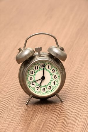 Small Metal Alarm Clock on the Wood Surfaceの写真素材