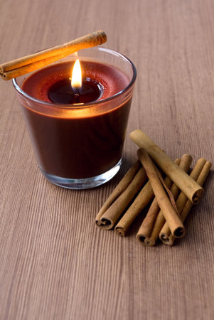 Candle in the glass and cinnamon sticksの写真素材