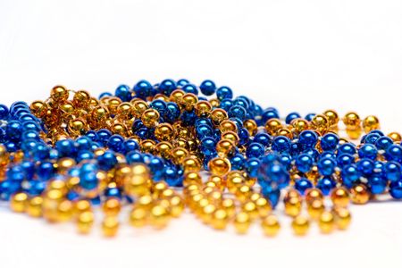 Blue and golden decoration beads lying on white backgroundの写真素材