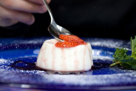 Delicious panna cotta dessert with strawberry, mint and chocolate sauceの写真素材