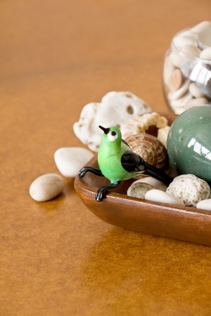 Little green glass bird in wooden plateの写真素材
