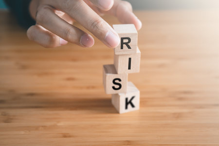 Businessman hold wooden block with risk text. risk management, protection, business concept.の写真素材