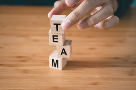 Businessman hold wooden block with  Team text. teamwork and organization conceptの写真素材