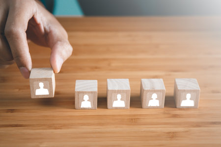Businessman hold wooden block of staff icons. teamwork and organization conceptの写真素材
