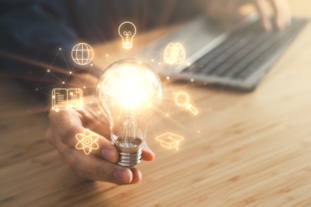Business man holding light bulb and laptop, keyboard and mouse. New idea, innovation technology and creativity concept.の写真素材