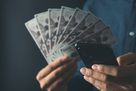 Global Economic and exchange rate on currency stock market. business man holding banknote and using phone  for US dollar index concept.の写真素材