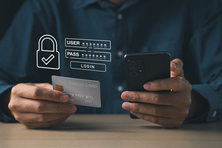 Businessman using mobile phone with cyber security login screen and holding credit card. Digital information technology and cyber security concept.の写真素材