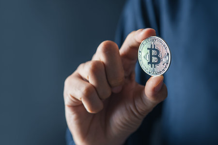 Bitcoin Blockchain Technology and Cryptocurrency. Hand holding bitcoin for Digital Finance and...
