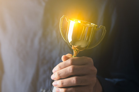 business man holding a trophy from his success. Business reward for your effort for success in your lifeの写真素材