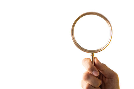Hand holding magnifier tool isolated on white background. discover and research concept.の写真素材