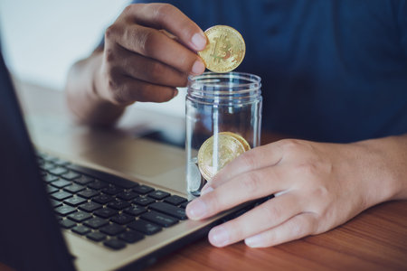 Man holding a gold Bitcoin. Make money with bitcoin, digital currency money investment concept,...