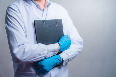 doctor working with clipboard of medication history records in clinic at his working place, closeup. Perfect medical service in hospital.の写真素材