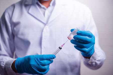 Doctor holding tube with Coronavirus vaccine and syringe. Healthcare And Medical concept.の写真素材