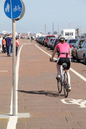 shot of a woman excercising on a bike outside in a dedicated cycle lane.の写真素材