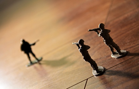 two toy soldiers ready to capture an opposing toy soldier on his own.の写真素材