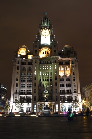 a full front shot of the iconic liverpool liver building at the docks lit up at nightの写真素材