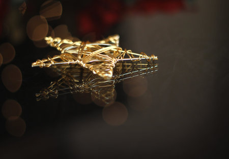 a gold star decoration on reflective glass shot at a low aperature.の写真素材