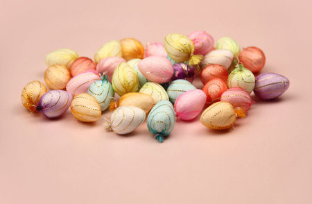 small colourful easter eggs lying on a pink background shot in a studio 