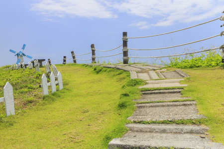 Windmill, fence and path with blue sky in Taitung, Taiwanの写真素材