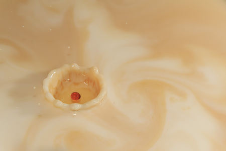 Splashing coffee drop into milk, turn the background as artの写真素材