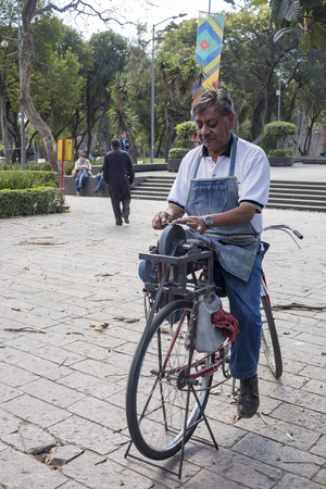 Mexico City, FEB 16: Man is polishing his knife on a bicycle on FEB 16, 2017 at Mexico Cityのeditorial素材