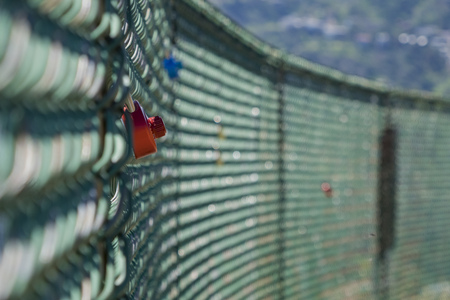Red lock locking at a fence on morningの写真素材