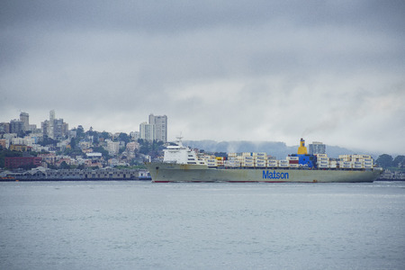 San Francisco, APR 17: The beautiful skyline of San Francisco with a big cargo ship in a cloudy day on APR 17, 2017 at San Francisco, Californiaのeditorial素材