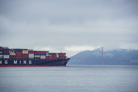 San Fransisco, APR 17: The famous and beautiful Golden Gate Bridge with a big cargo ship nearby on APR 17, 2017 at San Francisco, Californiaのeditorial素材