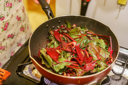 Frying delicious beets and leaves in a non stick pan at home, Los Angeles