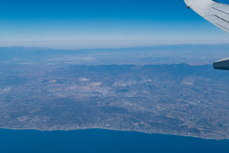 Aerial view of the shore of Los Angeles County in an airplane window seatの写真素材