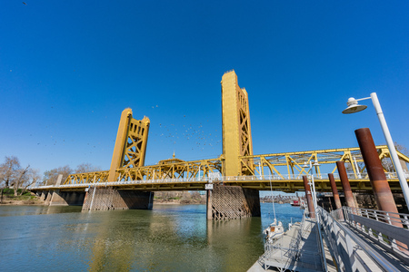 Groups of pigeons flying over the famous tower bridge of Sacramento, Californiaのeditorial素材