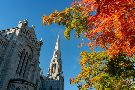 Exterior morning view of the Basilica of Sainte-Anne-de-Beaupre church with red maple tree at Quebec, Canadaの写真素材