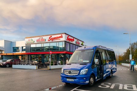 Dublin, OCT 27: Exterior view of a building of three fast food restaurant - Supermac, Supersub & Papa John  with a tour bus in front on OCT 27, 2018 at Dublin, Irelandのeditorial素材