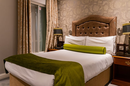 Dublin, OCT 27: Interior view of a room in a hotel with green and white sheet bed on OCT 27, 2018 at Dublin, Irelandのeditorial素材