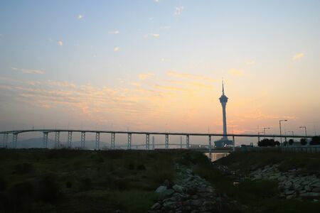 Sunset view of the Governador Nobre de Carvalho Bridge with the Macau Tower Convention and Entertainment Center at Chinaの写真素材