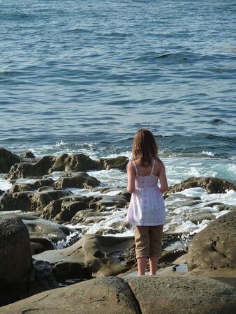 Little girl playing along the beautiful coast at Lo Jolla, Californiaの写真素材
